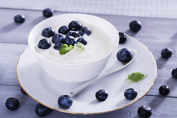 yogurt and blueberry on white wooden table. Healthy nd tasty  breakfast. - Φωτογραφία, εικόνα