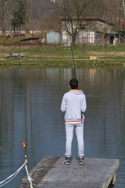 Poika kalastamassa lähellä järveä
 - Valokuva, kuva