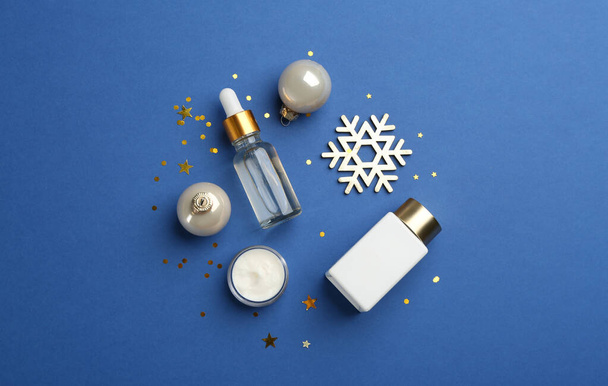 Flat lay composition with cosmetic products on blue background. Winter care - Фото, изображение