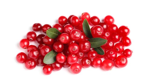 Pile of fresh cranberries with green leaves on white background, top view - Foto, afbeelding
