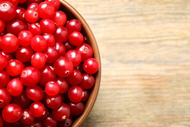 Tasty ripe cranberries on wooden table, top view. Space for text - Фото, изображение