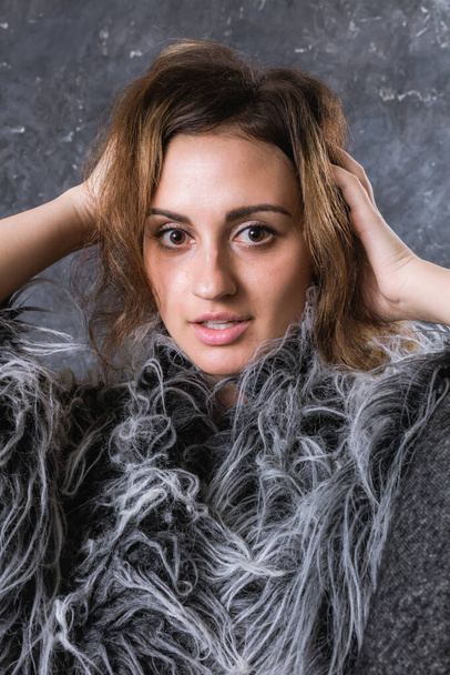 Pretty young woman dressed in fur coat - Foto, Imagen