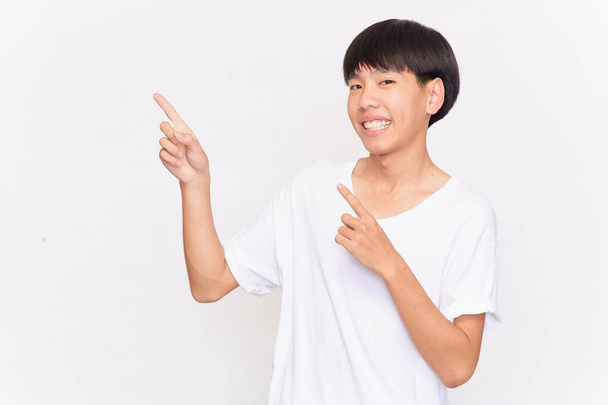 portret van een jonge Aziatische man met handpunt op lege ruimte geïsoleerd op witte achtergrond - Foto, afbeelding