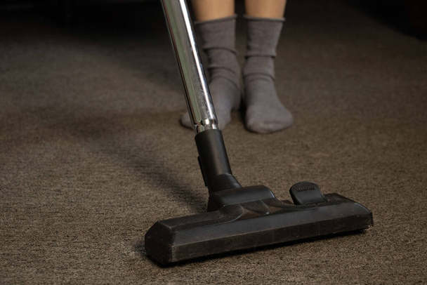 naisten jalat sukat matto ja pölynimuri, puhdistus huoneisto - Valokuva, kuva