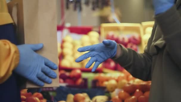Primer plano de pareja joven en guantes azules peleando en el mercado - Metraje, vídeo