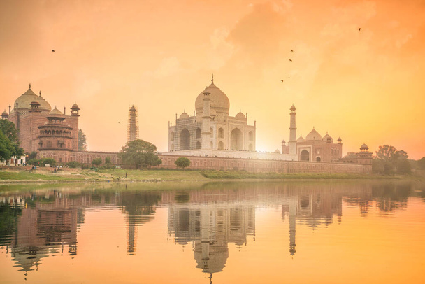 インドのアグラでの反射と日没のタージ・マハルのパノラマビュー. - 写真・画像