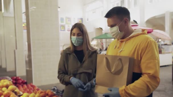 Junges Paar in Schutzmaske und blauen Handschuhen streitet auf dem Markt - Filmmaterial, Video