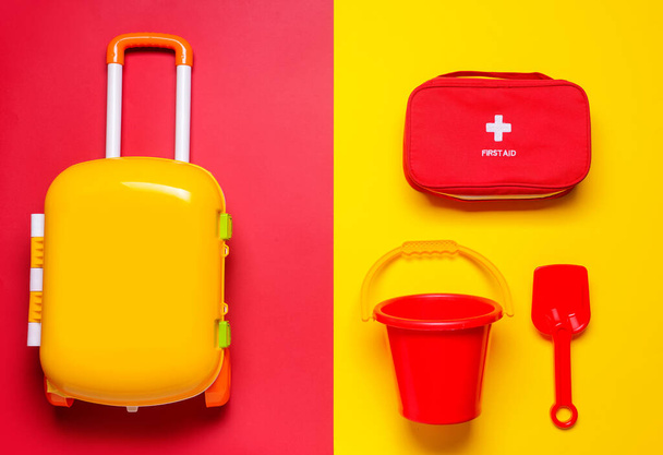Flat lay composition with child beach accessories and first aid kit on color background. Travel concept - Foto, immagini