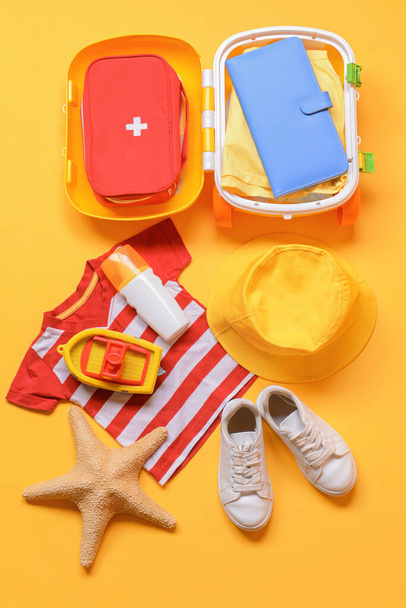 Küçük çocuk plaj aksesuarları ve ilk yardım çantasıyla renklendirilmiş düz kompozisyon. Seyahat kavramı - Fotoğraf, Görsel