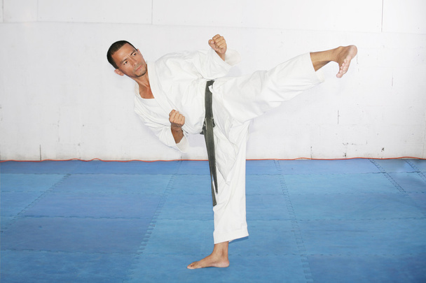 Mann praktiziert Kampfkunst im Fitnessstudio - Foto, Bild