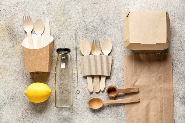 Ekoruokailuvälineet, lasipullo ja astiat harmaalla pohjalla olevaa ruokaa varten - Valokuva, kuva