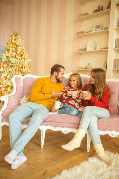 Cute family sitting on the sofa and feeling comfortable - Foto, afbeelding