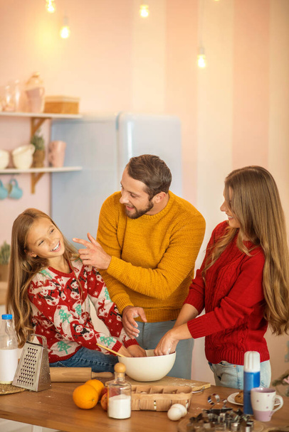 Kid and her parents cooking together in the kitchen and feeling awesome - Fotoğraf, Görsel