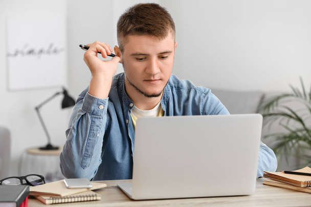 Молода людина використовує ноутбук вдома
 - Фото, зображення