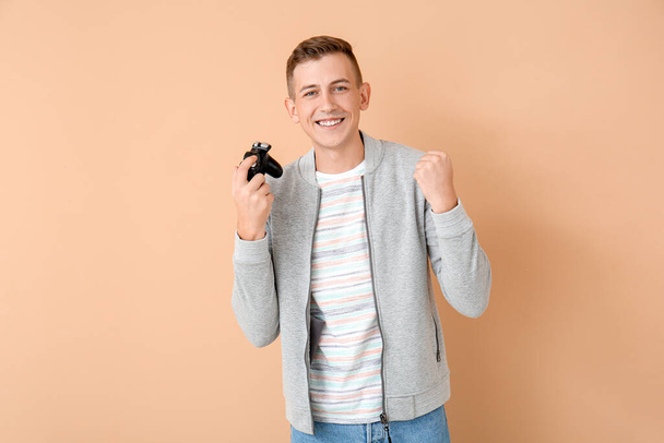 Happy young man playing video games on color background - Foto, immagini