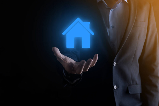 Real estate concept, businessman holding a house icon.House on Hand.Property insurance and security concept. Protecting gesture of man and symbol of house - Photo, Image