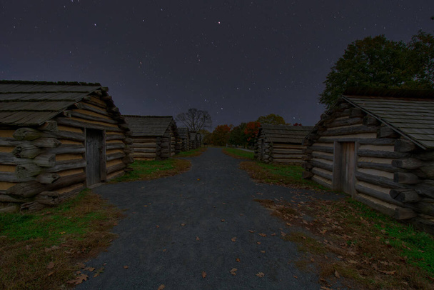 Cabañas de registro de reproducción en Valley Forge Parque Histórico Nacional con un cielo nocturno lleno de estrellas detrás - Foto, imagen