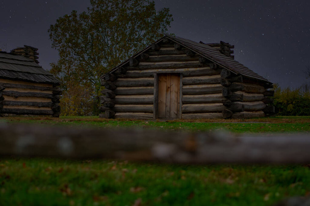 Voortplanting hutten in Valley Forge National Historical Park met een nachtelijke hemel vol sterren achter - Foto, afbeelding