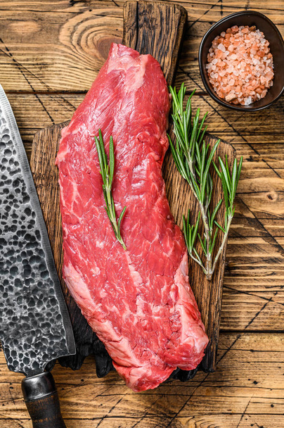 Syrový steak z hovězího masa na řezací desce s nožem. dřevěné pozadí. Horní pohled. - Fotografie, Obrázek