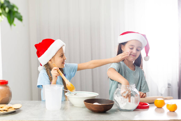 two little girls prepare Christmas cookies in the kitchen - Fotoğraf, Görsel