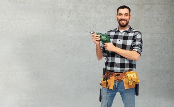 happy male worker or builder with drill and tools - Фото, зображення