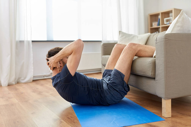 man making abdominal exercises at home - Zdjęcie, obraz