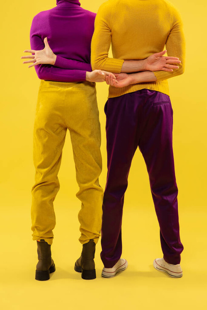 Обрезанный снимок двух стильных одетых людей, стоящих со скрещенными руками - Фото, изображение