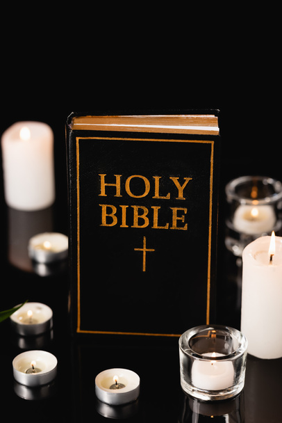 candles and holy bible on black background, funeral concept - Photo, Image