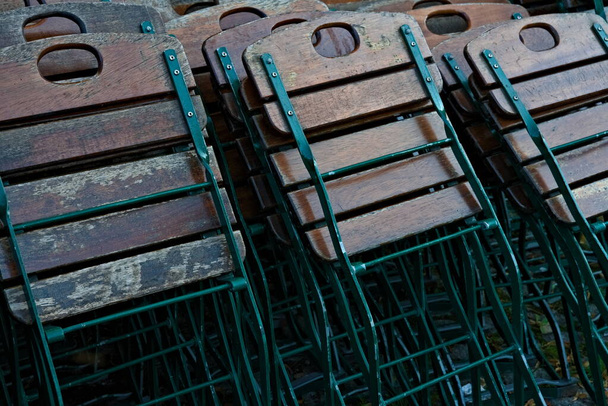 Składane krzesła wykonane ze stali i drewna stojącego w zawalonych w wielu rzędach.  - Zdjęcie, obraz