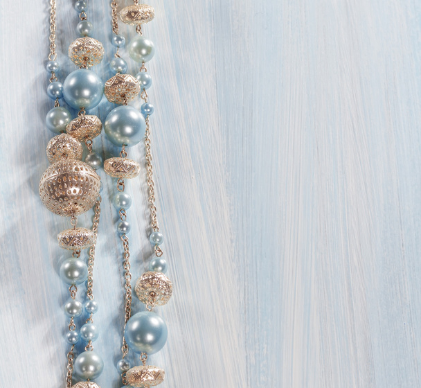 Blue beads on a wooden background - Foto, afbeelding