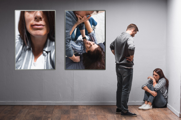 Abuso olhando para a esposa com hematomas perto de fotos de violência doméstica na parede - Foto, Imagem