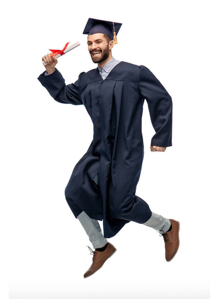 happy jumping graduate student with diploma - Foto, Imagen