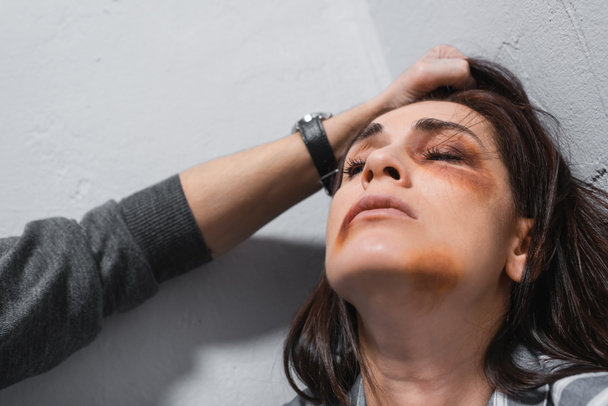 Marido abusivo segurando o cabelo da esposa com hematomas no rosto  - Foto, Imagem