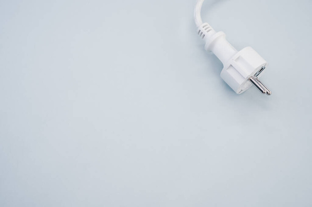 A high angle shot of a white electrical plug and wire on a white surface - Photo, image