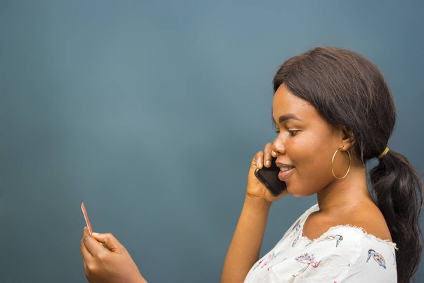 A closeup shot of a beautiful young African lady talking on her phone - Foto, afbeelding