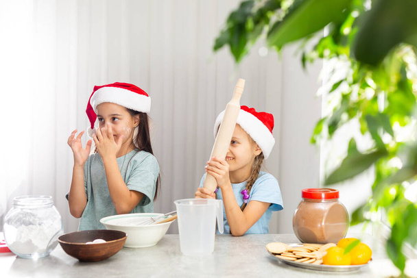 дві маленькі дівчата готують різдвяне печиво на кухні
 - Фото, зображення