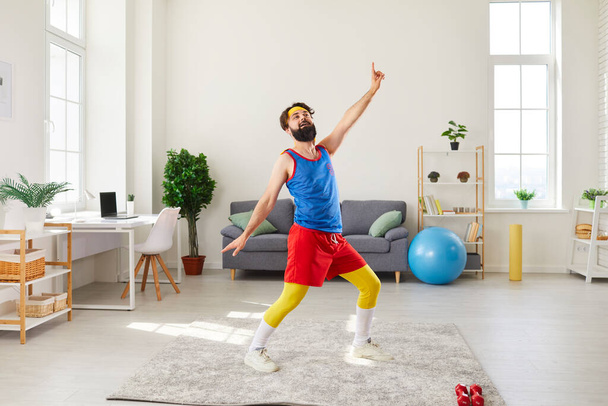Funny man doing fitness exercise, dancing and fooling around during workout at home - 写真・画像