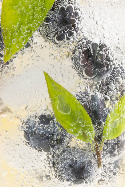 A vertical closeup shot of blueberries in sparkling water - 写真・画像