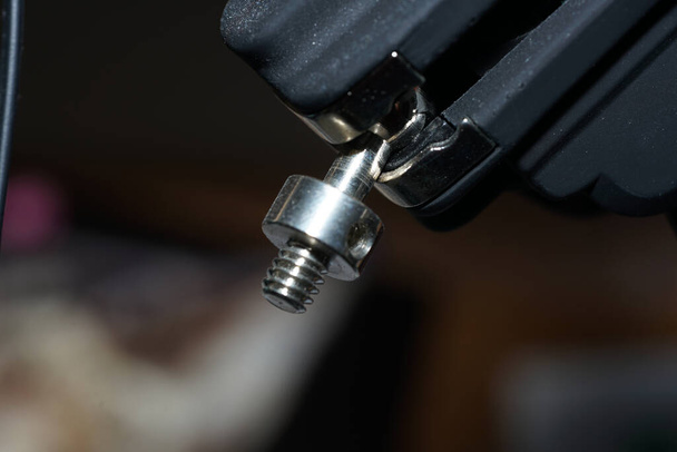 A closeup shot of a special instrument holding a stainless steel bolt fastener - Foto, imagen