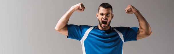 Excited sportsman with open mouth showing yeah gesture isolated on grey, banner  - Photo, Image