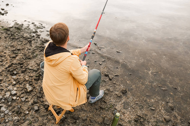 Jeune homme pêche sur la rivière - Photo, image