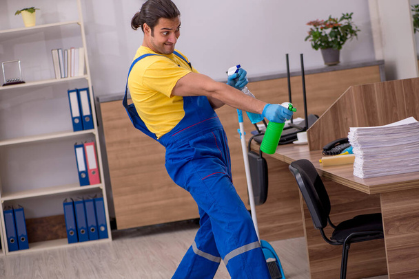 事務所を掃除する若い男の請負業者 - 写真・画像