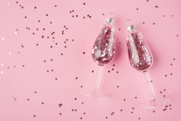 Concepto de celebración de año nuevo. Arriba arriba vista aérea foto de copas de champán con confeti en el interior aislado sobre fondo rosa pastel con confeti - Foto, imagen