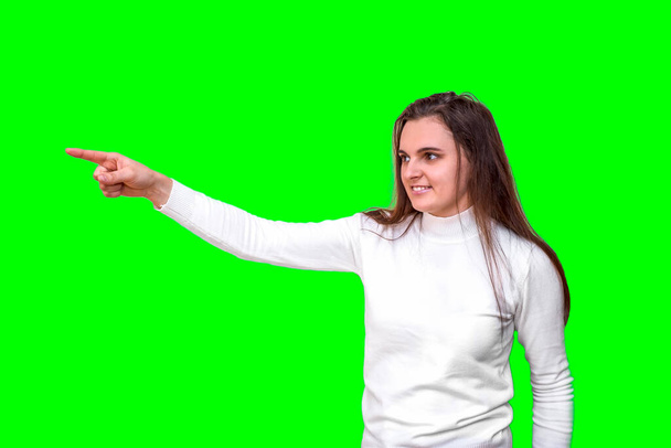 Uma mulher sorridente e confiante em pontos brancos para o seu produto. Isolado em fundo verde. Modelo europeu. - Foto, Imagem