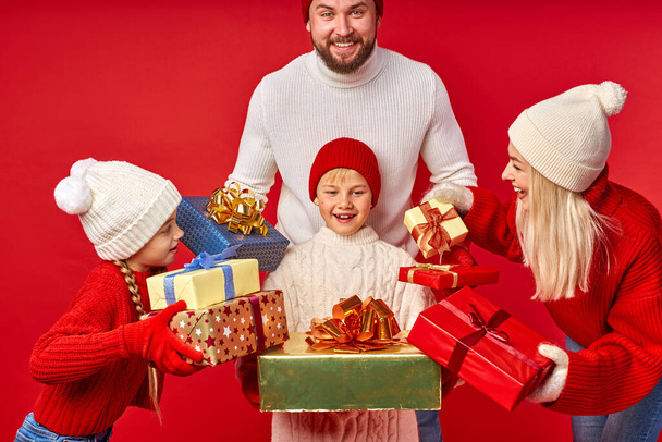 cheerful kid boy get Xmas gifts from parents and sister - 写真・画像