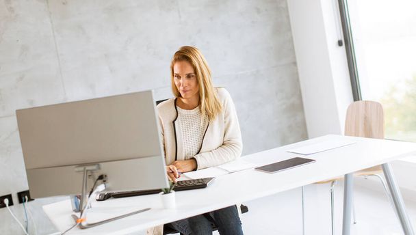 Bbeautiful üzletasszony dolgozik laptop a fényes modern irodában - Fotó, kép
