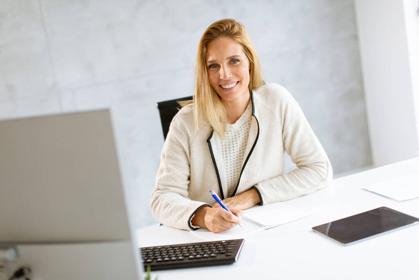 Schöne Geschäftsfrau am Laptop im hellen, modernen Büro - Foto, Bild