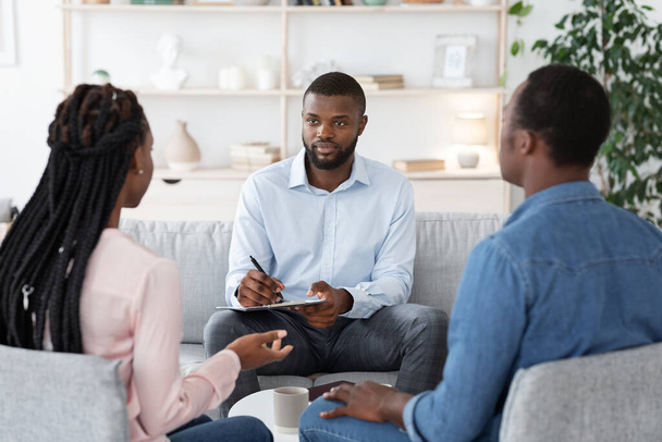 Profesjonalny doradca małżeński słuchanie problemów czarnej pary Millennial podczas sesji terapeutycznej - Zdjęcie, obraz