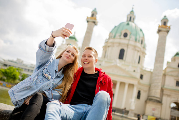Fiatal pár, akik szelfit készítenek a Szent Péter katolikus templom mellett Bécsben, Ausztriában - Fotó, kép