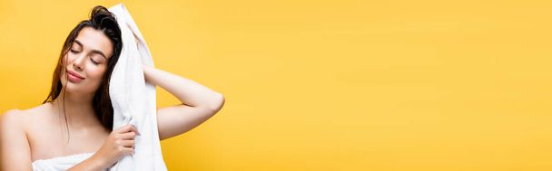 smiling beautiful woman with wet hair and towel isolated on yellow, banner - Foto, afbeelding